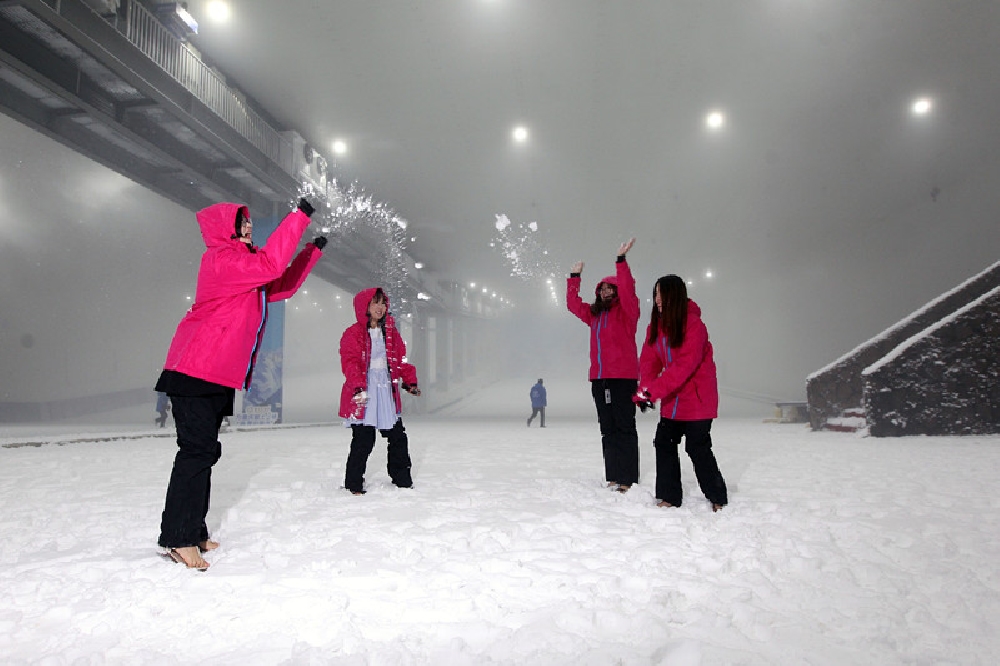 两江新区重庆际华园室内滑雪场,参观者身着羽绒服体验奇妙的冰雪世界