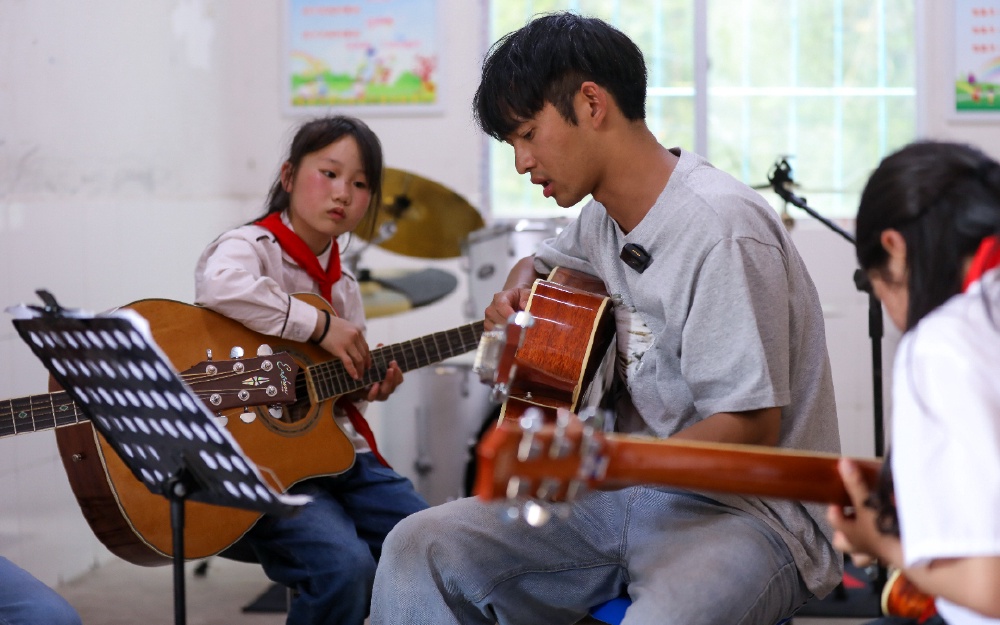 4.2024年5月31日，大巴山深处的巫山县三溪乡田家小学石印村教学点，庄济宇在琴房内为孩子们弹奏、做示范。.jpg