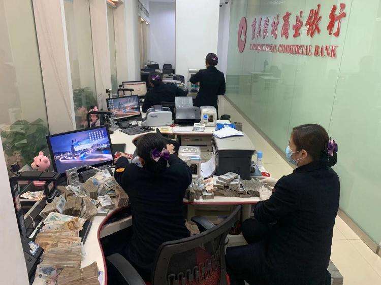 图为重庆农商行江津分行营业部工作人员正在为万女士清点零散现金。.jpg
