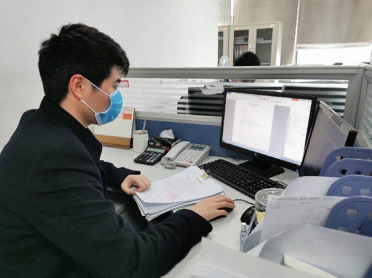 图为重庆农商行江北支行营销三部客户经理王永正在整理重庆力丰建筑工程有限公司延长贷款期限的相关资料。.jpg