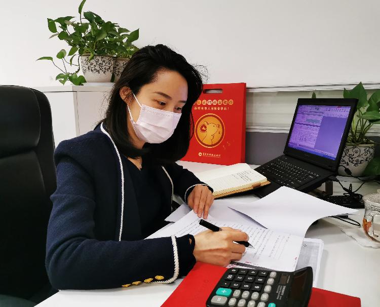 图为：重庆农商行渝中支行信贷客户经理柳丹正在整理重庆伊莎贝莲服饰有限公司贷款展期资料。.jpg