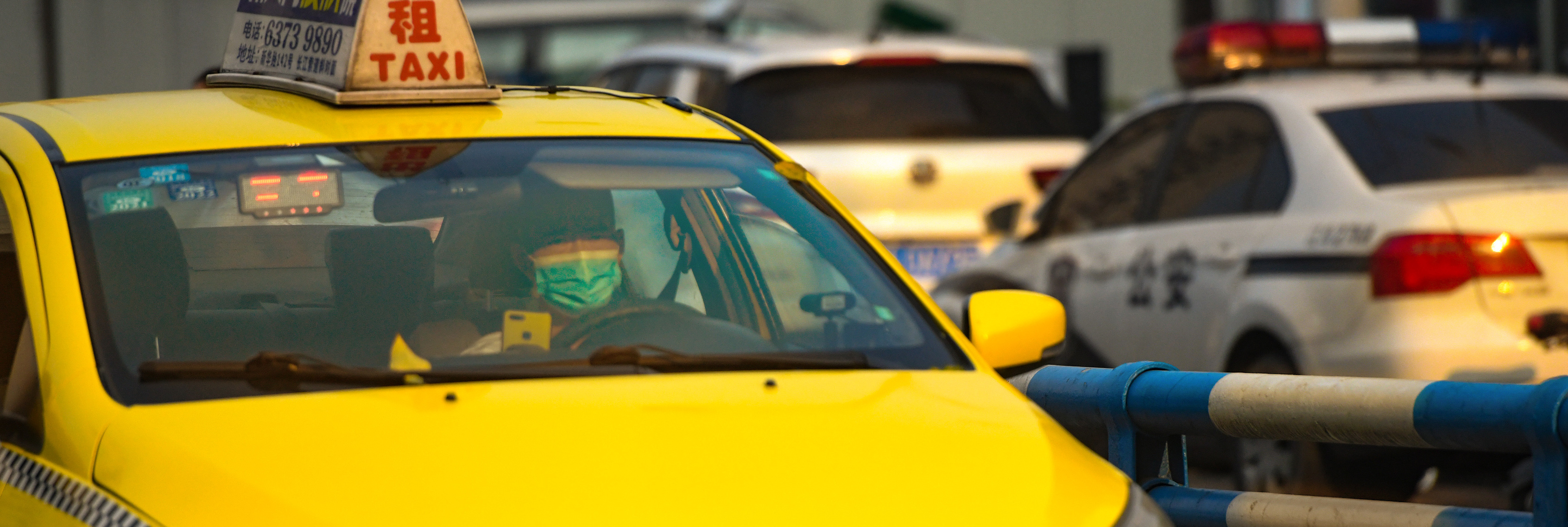 8月6日,在江北区盘溪二支路,一名出租车司机迎着阳光驾驶着车辆前行